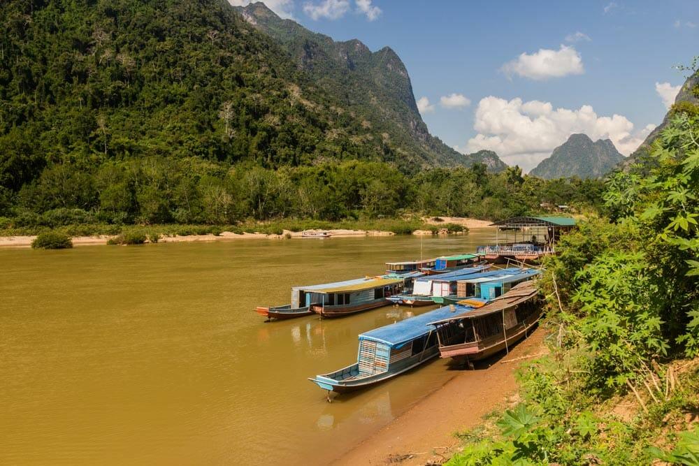 barche nel fiume davanti al villaggio di Muang Ngoi Neua, in Laos
